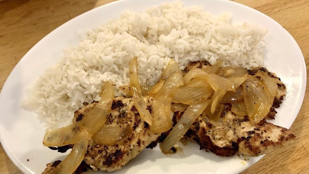Pollo A La Plancha · Boneless chicken breast marinated in lemon and garlic, grilled and smothered with onions. Served with rice and black beans.