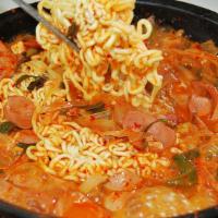 Budae Stew (Budae Jjigae) · Hot & spicy kimchi base soup with ham, sausage, pork belly, mixed vegetables, ramen noodle.