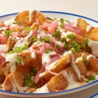 Loaded Potato Wedges · Spicy Potato Wedges topped with Melty Cheese, Bacon, Green Onions, Red Onions, and Ranch.