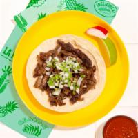 Carne Asada Taco · Marinated steak topped with cilantro and chopped onion on a soft corn tortilla.