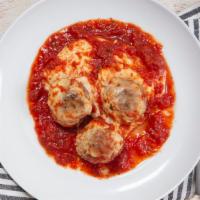 Zesty Meatballs · Three meatballs topped with melted mozzarella cheese and tomato sauce.