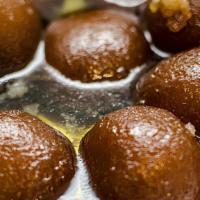Gulab Jamun · Reduced milk balls served in rose flavored sugar syrup and a touch of cardamom powder.
