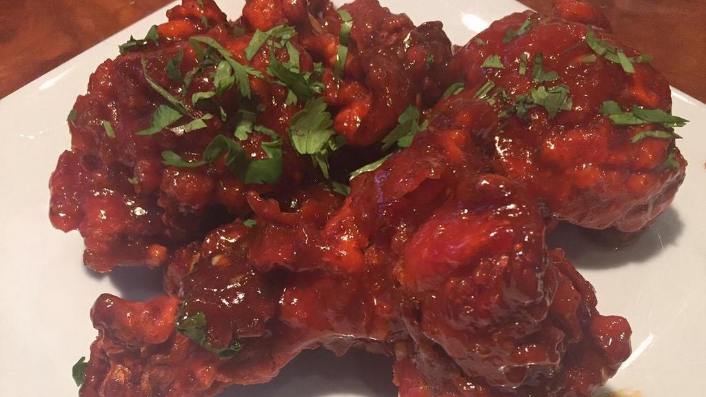 Chicken Lollypop · Pulled back chicken wings cooked in a spicy red batter.