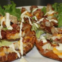 Potato Skins · Bacon, cheese topped with chives. Served with sour cream and ranch.