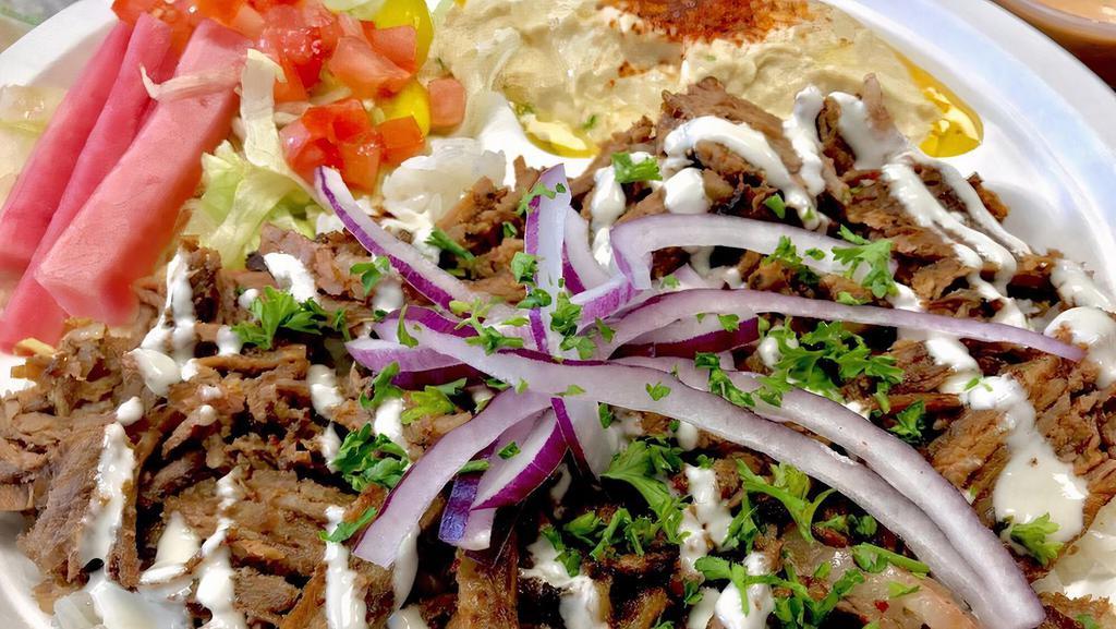 Beef Shawarma Plate · Served with Rice, Hummus, Salad topped with Onions drizzled with Tahini. Pita Bread.
