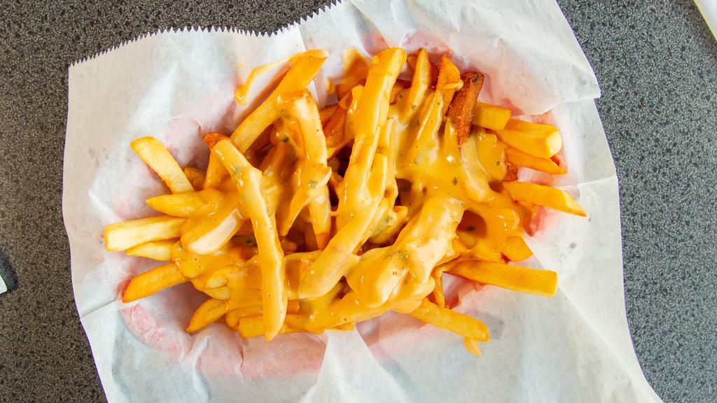Queso Fries · Fries topped with queso cheese.