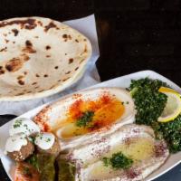 Mezze Plate Sampler · Vegetarian. Order of hummus, Baba ghanouj, tabouli salad, grape leaves and falafel topped wi...