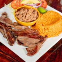 Carne À La Plancha · Grilled marinated steak served with rice, beans, lettuce, and pico de gallo.
