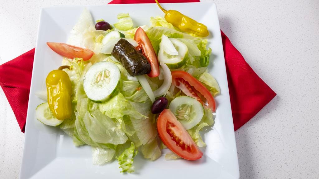 Greek Salad · Ice berg Lettuce, Tomato, Cucumber, Onions, Feta cheese, Olives, Peppercini, Stuffed Grape leaves