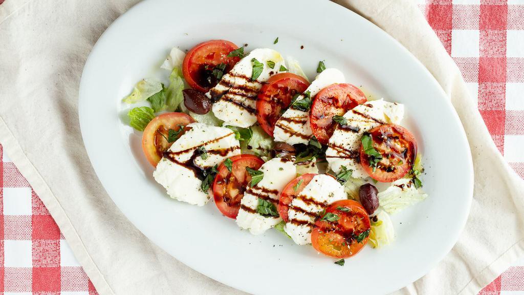 Mozzarella Caprese · Fresh mozzarella, sliced tomatoes, basil, salt, peppers, and olive oil balsamic glaze.