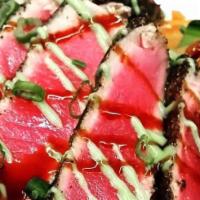 Seared Ahi Tuna · Sashimi-grade tuna coated finely ground black pepper and pan rare, served with spicy Asian s...