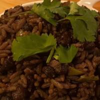 Moros Y Cristianos · Mixed and seasoned rice and black beans.
