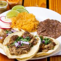 Carnitas Taco Platter · Three braised pork tacos served with Mexican rice, and refried beans. Topped with cilantro, ...