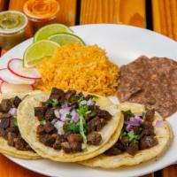 Lengua Taco Platter · Three beef tongue tacos served with Mexican rice, and refried beans. Topped with cilantro, o...