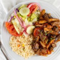 Lomo Saltado · Strips of beef sautéed with potatoes, tomatoes and onions, served with rice and salad.