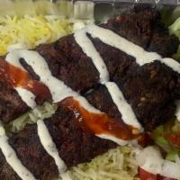 Beef Kebab Plate · Rice, lettuce, tomato, cucumber, pickle, feta cheese, white sauce, and red sauce.