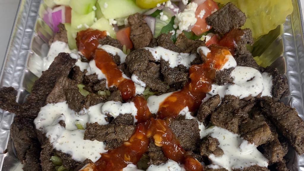 Beef Shawarma Over Salad · lettuce, tomato, cucumber, pickle, feta cheese, white sauce, and red sauce.