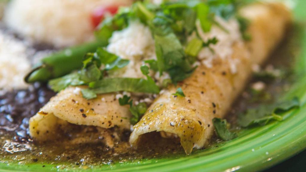 Enchiladas Verdes · Two chicken soft tacos topped with our green tomatillos sauce and cheese served with rice, black beans, and nopalitos salad.