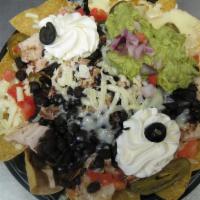 Nachos Grande · A bed of fresh, crisp tortilla chips topped with melted cheese, black beans, grilled chicken...