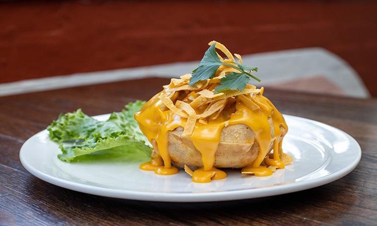 Stuffed Puffy Queso · Los Tios famous puffy crispy shell stuffed with grilled chicken or beef, refried beans, lettuce, and guacamole, topped with chile con queso and tortilla strips.