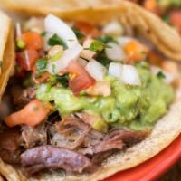 Carne Asada Tacos · Two soft corn tortillas filled with grilled and chopped marinated steak. Topped with guacamo...