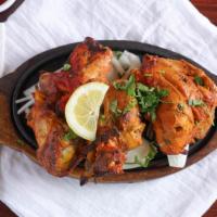 Chicken Tandoori · Marinated chicken breast flavored with herbs and spices cooked in clay oven.