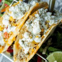 Street Taco Duo · Two crispy corn tacos, a pork carnitas & a southwest chicken, encased in a cheesy flour tort...