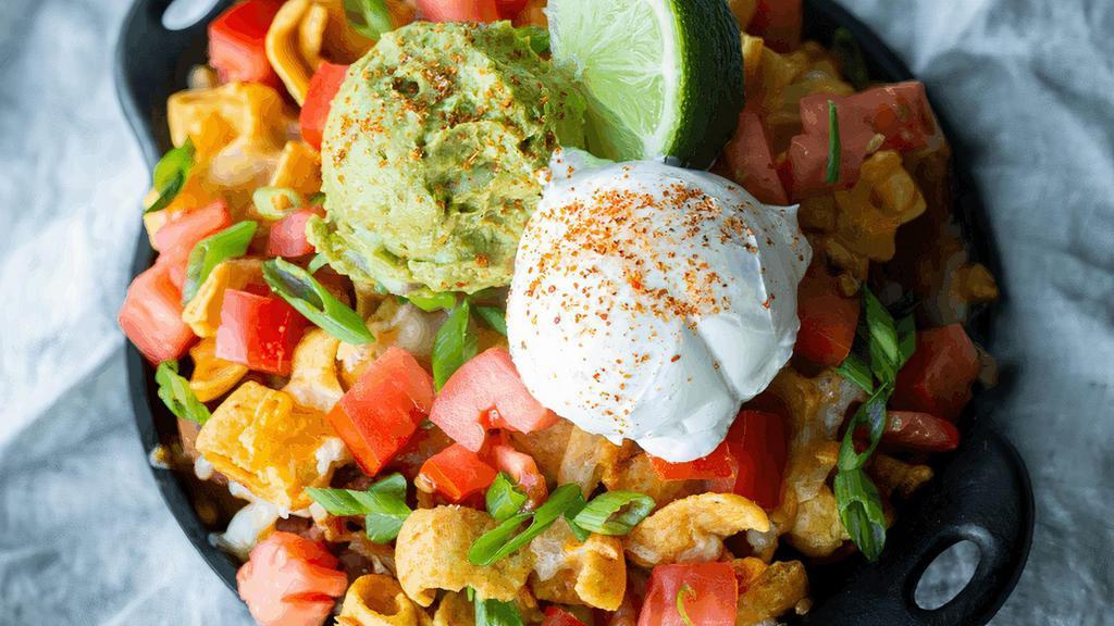 Frito Pie · Fritos corn chips baked with our signature chicken chili, cheddar & jack cheese. Topped with diced tomatoes, scallions, house-made guacamole & sour cream, dusted with Tajín. (cal 830)
