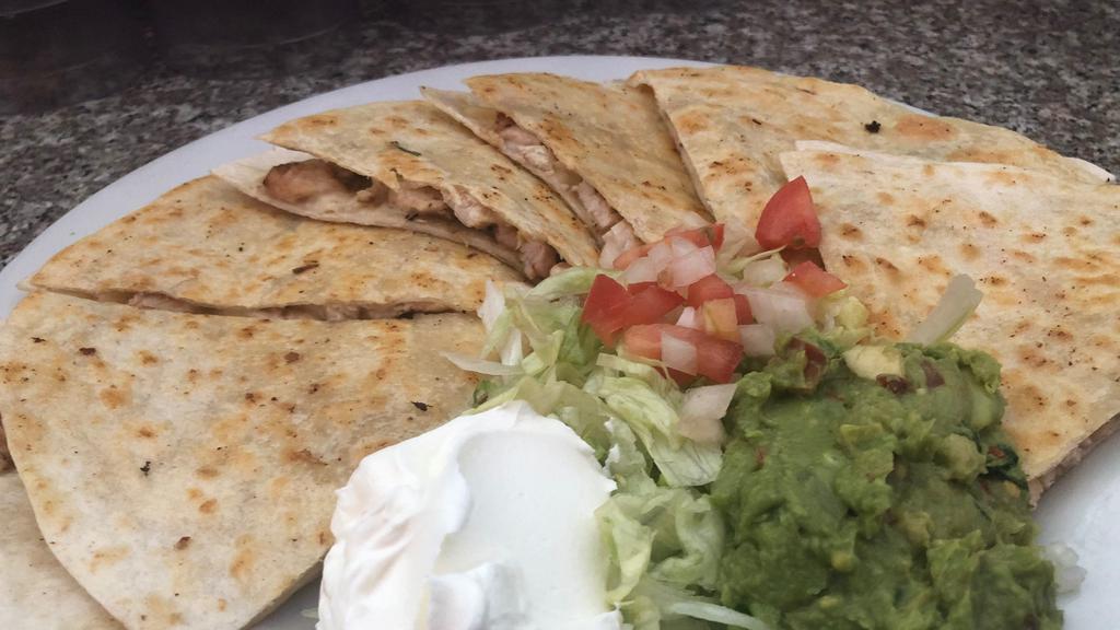 Grilled Chicken Quesadilla · Grilled flour tortilla stuffed with charbroiled chicken and jack cheese garnish with tomatoes onions sour cream and guacamole