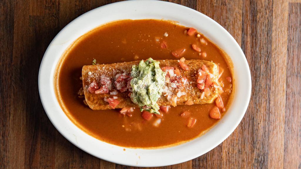 Expreso Burrito · Pork Chile verde rice beans and cheese wrapped in a flour tortilla covered with red sauce garnish with tomatoes onions guacamole and Parmesan cheese
