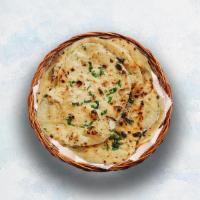 Garlic Naan · Indian flatbread baked to perfection in a traditional Indian clay oven and sprinkled with mi...