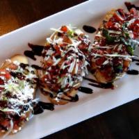 Lunch Tomato Bruschetta · Baguette, goat cheese, balsamic glaze, basil oil and parmesan cheese.
