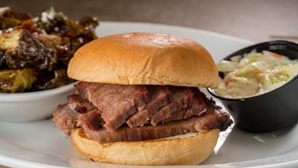 Texas Brisket Sandwich · Low-and-slow, smoked over pecan wood for 12 hours, with cole slaw, on a brioche roll.