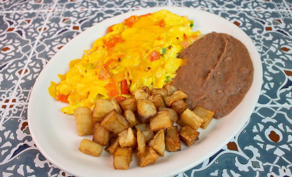 Chilaquiles Plate · Two scrambled eggs cooked with tortilla chips and pico de gallo, topped with melted cheese, served with breakfast potatoes, beans, and two tortillas.