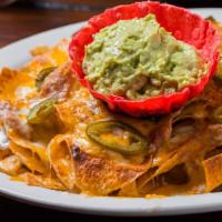 Mi Casa Nachos (Regular) · Crispy corn chips and cheese baked to perfection then topped with beans, sour cream, guacamo...