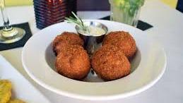 Papas Rellenas · Seasoned mashed potatoes generously stuffed with flavorful ground beef, breaded and lightly fried. Served with garlic aioli sauce.