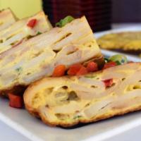 Tortilla Española · Gluten-free. Traditional Spanish potato and onion omelette. Served with olives, red peppers ...