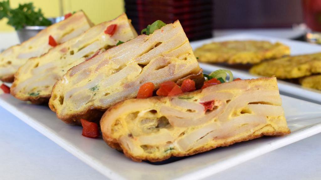 Tortilla Española · Gluten-free. Traditional Spanish potato and onion omelette. Served with olives, red peppers and garlic aioli sauce.