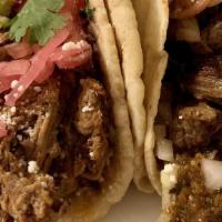 Barbacoa Taco · Slow braised shredded beef, guajillo chile salsa, guacamole, pickled red onions, pickled rad...