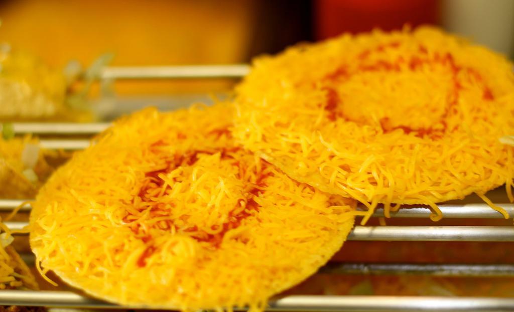 Cheese Tostada · It's so simple, yet so good. Enjoy a flat, crisp corn tortilla topped with freshly grated colby cheese and hot sauce, then melted. Order two, you'll thank us later. Gluten-Free.