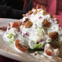 Wedge Salad · A wedge of iceberg lettuce topped with house-made blue cheese dressing, red onion, bacon bit...