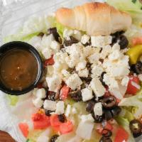 Greek Salad · Salad greens topped with feta cheese, onions, pepperoncini peppers, tomatoes, and black oliv...