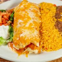 Shredded Beef Burrito · Topped with red chili sauce. A large flour tortilla rolled with shredded beef and covered wi...