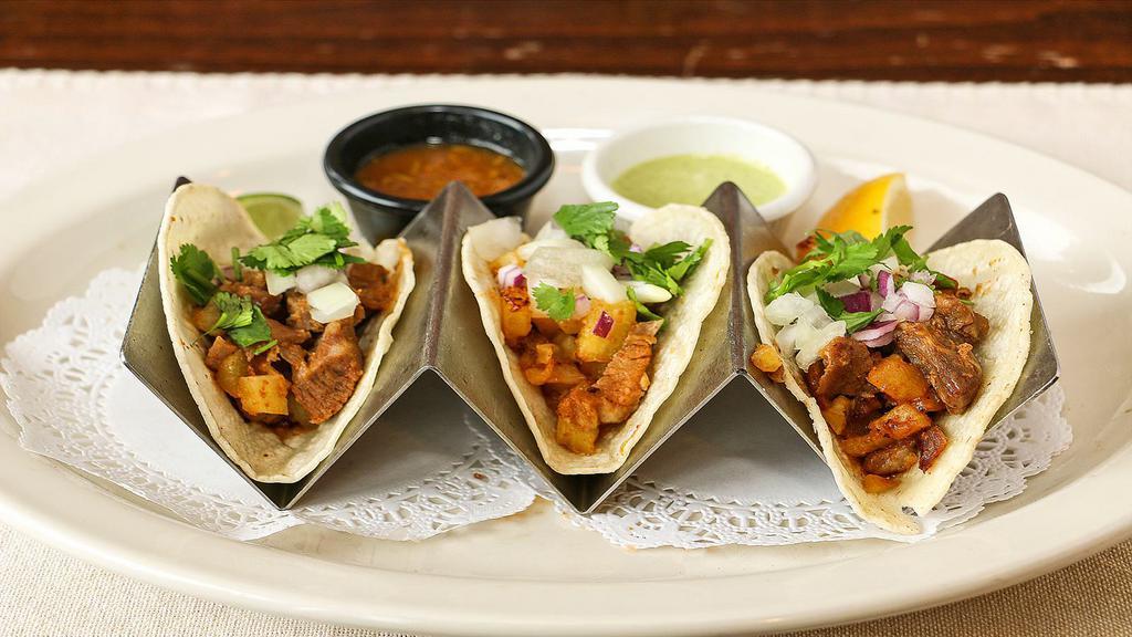 Tacos Al Pastor · Three soft corn tortillas filled with marinated grilled pork loin, onion, pineapple, and cilantro. Served with white rice, refried beans, sour cream, and pico de gallo on the side.