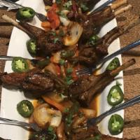 Lamb Chops · 4 grilled lamb chops served with rice and salad.