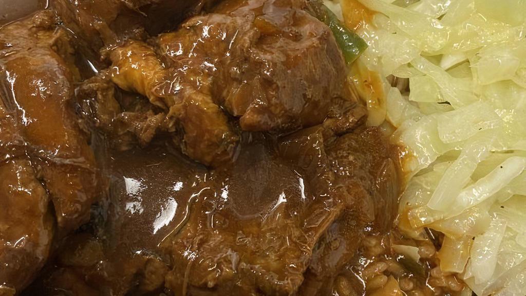 Brown Stew Chicken · Fall off the bone Jamaican brown chicken stew. Served with steam cabbage and rice and peas.