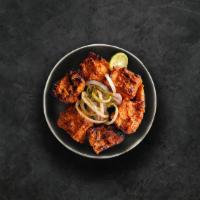 Charred Chicken Tikka · Succulent morsels of chicken, marinated in tandoori masala and yogurt, cooked in an Indian c...