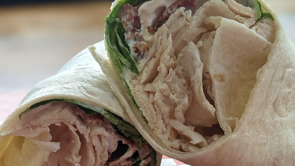 Chicken Bacon Ranch Wrap · Sliced chicken on a tortilla wrap with bacon , ranch dressing, lettuce and tomato.