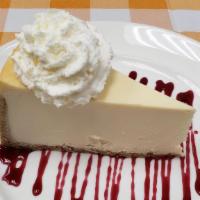 Steakhouse Style Cheesecake · Large piece of silky cheesecake on graham cracker crust topped with choice of raspberry, cho...