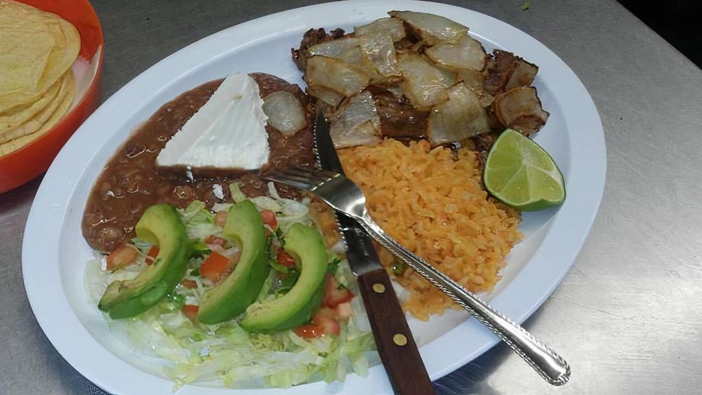 Carne Asada · Seasoned Sirlon served with, grilled cambray onion, jalapeño, rice,
beans, salad, avocado and your choice of flour or corn tortillas.